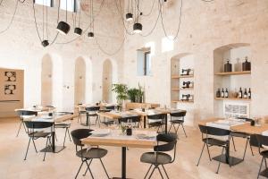 un restaurante con mesas y sillas en una habitación en Villa Torre Bianca by Emily Hotels, en Polignano a Mare