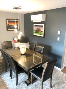 a dining room with a black table and chairs at Luxurious Apartment in Brossard with Terrace in Brossard +4 photos
