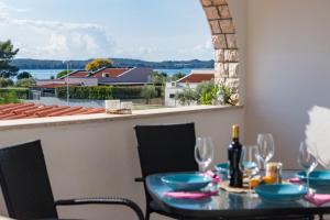 a table and chairs on a balcony with a view of the water at Casa Zen in Fažana
