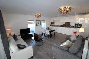 a living room with a couch and a dining room at East Coast - Beautiful and modern holiday home in Bournemouth