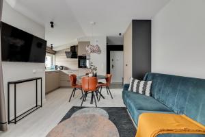 ソポトにあるLion Apartments - Monte Carlo Deluxe with parkingのリビングルーム(青いソファ、テーブル付)