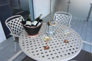 a table with a bucket of wine bottles and wine glasses at East Coast - Beautiful and modern holiday home in Bournemouth