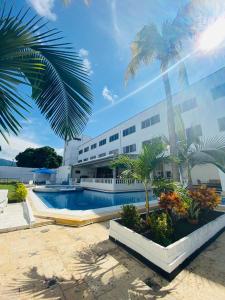 een gebouw met een zwembad en palmbomen bij Hotel Mall Santana Del Río in La Dorada