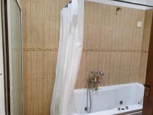 a white bath tub with a shower curtain in a bathroom at Apartament Roma in Braşov