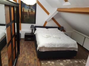 a bedroom with a bed with white sheets on it at Apartament Roma in Braşov