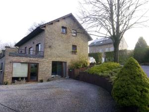 une grande maison en briques avec une clôture devant elle dans l'établissement Votre Horizon, à Aywaille