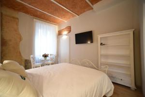 a bedroom with a white bed and a tv on the wall at Casa Martimbola Self Check-in in Arezzo