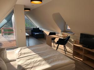 Mödlich的住宿－Hotel Alte Fischerkate，一间卧室配有一张床、一张书桌和一台电视