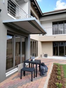 a patio with a black table in front of a house at HWH Guesthouse Middelburg in Middelburg