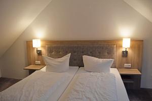 ein Schlafzimmer mit zwei Betten mit weißen Laken und Kissen in der Unterkunft Aparthotel Jägerhaus in Willingen