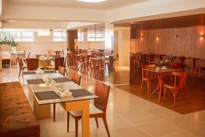 a dining room with tables and chairs and a restaurant at Vip Hotel in Jaú