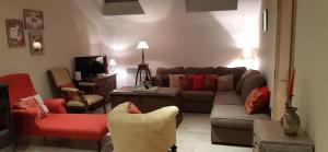 un soggiorno con divano, sedie e TV di Le Maffe de Scourmont a Chimay