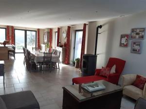 sala de estar con sofá rojo y mesa en Le Maffe de Scourmont, en Chimay