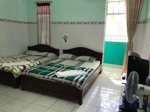 1 Schlafzimmer mit 2 Betten und einem Fenster in der Unterkunft Motel HAPPY in Bà Rịa