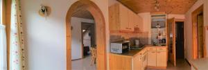 a kitchen with an archway in the middle of a room at Jakoberhof- Bergeweise Urlaubsfeeling in Untertscheltsch