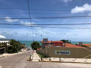 una calle vacía con un cartel en un lado de un edificio en Apart Hotel Litoral Sul en Natal