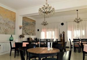 Hostal Montsoliu في أربوثياس: غرفة طعام بها طاولات وكراسي وثريا