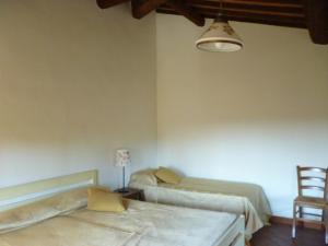 リオトルトにあるRustico Sant'Emilioのベッドルーム1室(ベッド2台、ランプ、椅子付)