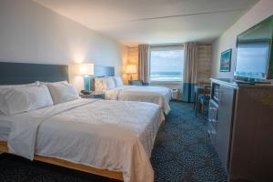 a hotel room with two beds and a flat screen tv at Holiday Inn Resort South Padre Island-Beach Front, an IHG Hotel in South Padre Island