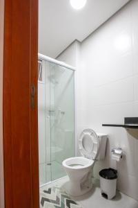 un bagno con wc e doccia in vetro di Home Resort Palmeiras II - proximo Praia Grande a Ubatuba