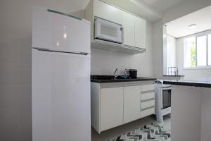 una cucina bianca con frigorifero e lavandino di Home Resort Palmeiras II - proximo Praia Grande a Ubatuba Altre 55 foto
