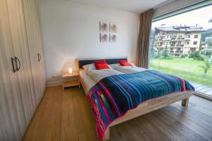 a bedroom with a bed and a large window at Eden Mountain Resort - Duke in Arosa