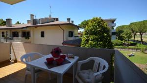 a small white table and chairs on a balcony at Villa Lucia in Lignano Sabbiadoro