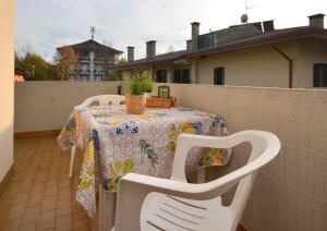 una mesa y sillas sentadas en un balcón en Villa Lucia, en Lignano Sabbiadoro
