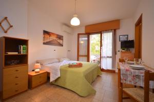 1 dormitorio con 1 cama con mesa y TV en Villa Lucia, en Lignano Sabbiadoro
