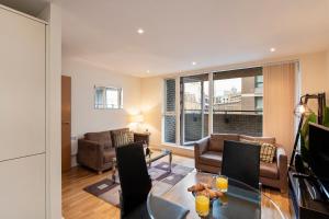 a living room with a table and chairs and a couch at One Bed Apartment in Waterloo near Southwark in London