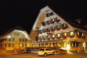 uma van branca estacionada em frente a um prédio em Hotel Löwen em Escholzmatt
