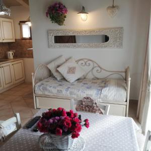 una habitación con una mesa con una cama y flores en ella en Hotel Tabby, en Golfo Aranci