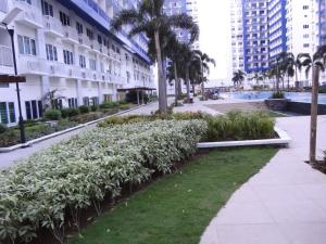 uma passarela com plantas e palmeiras numa cidade em manila sea view homes 21 em Manila