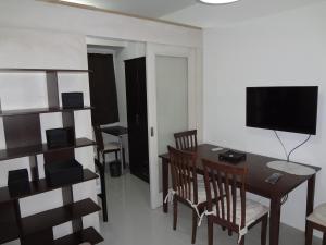 a dining room with a table and chairs and a television at manila sea view homes 21 in Manila