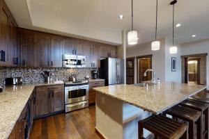 a large kitchen with wooden cabinets and a counter top at Trailhead Lodge 4100 in Steamboat Springs