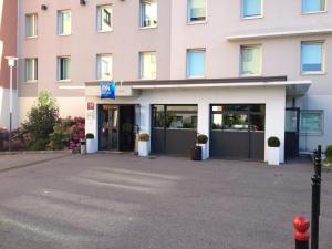 a large pink building with its doors open at ibis budget Velizy in Vélizy-Villacoublay