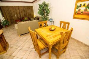 una mesa de madera y sillas en la sala de estar. en Las Palmas Resort Condo 403 with amazing sea view, en Puerto Peñasco