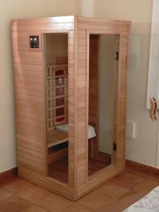 a wooden closet with glass doors in a room at Hotel Quadrifoglio Roma Eur in Mostacciano 