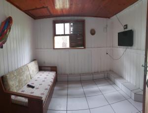 a room with a couch and a television in it at Pousada Villa Da Guarda in Guarda do Embaú