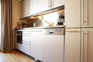 uma cozinha com armários brancos e um fogão em Modern & Central, Ambassadeurs em Crans-Montana