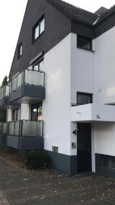 un bâtiment blanc avec un toit noir dans l'établissement Apartment am Hochseilgarten, à Löhne