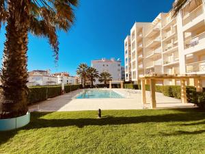 a palm tree and a swimming pool in front of a building at Vista by Check-in Portugal in Albufeira