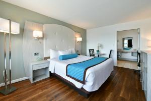 a bedroom with a large bed with blue and white sheets at The Freeport Inn and Marina in Freeport