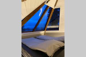 a bed in a room with large windows at Northernlight cabin in Kiruna