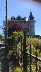 a fence in front of a house with flowers at Studio Terrasse Spa in Spa