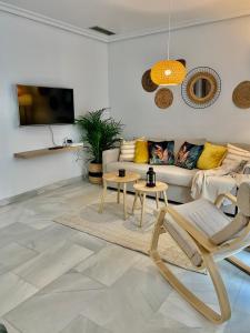 un soggiorno con divano, tavoli e TV di Homely Málaga Larios a Málaga