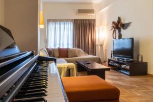 a living room with a piano and a couch at Dancing on Sunshine - Melina's City Getaway in Kalamata