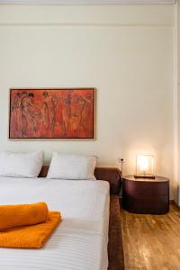 a bedroom with two beds and a table and a painting at Dancing on Sunshine - Melina's City Getaway in Kalamata