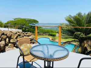 a table and chairs on a patio with a pool at Ollivanders Estate in KwaNgendezi