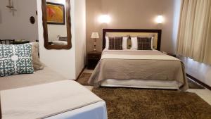 um quarto com 2 camas e um espelho em Pousada Cheverny - Fácil acesso ao centrinho e Baden Bar em Campos do Jordão